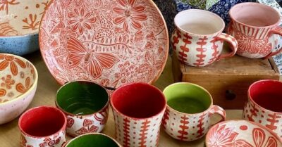 Handmade ceramic plates, mugs and bowls with sgraffito butterfly and floral designs in red and white by Susan Palmer, pottery instructor at A Maker's Circle in Pottersville NJ