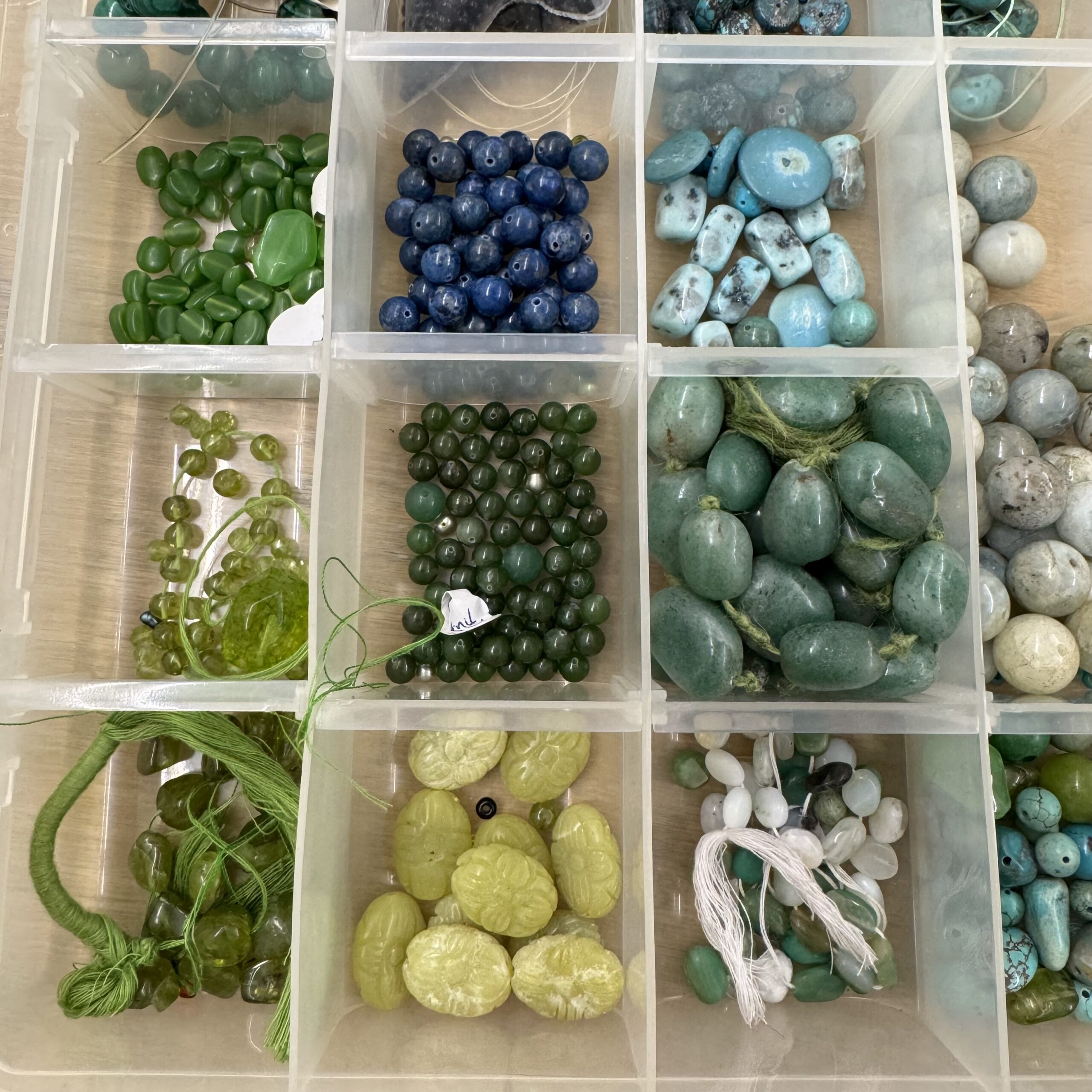 Organizer tray of jewelry-making beads in blue, turquoise, and green stone tones, used for the Beaded Jewelry project at A Maker's Circle's Art Bar in Pottersville, NJ