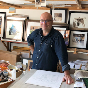 Marc Folly, guest watercolor workshop instructor at A Maker's Circle in Pottersville NJ, standing in his studio surrounded by his award-winning paintings